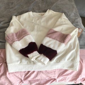 Cream sweater with fury sleeves.
